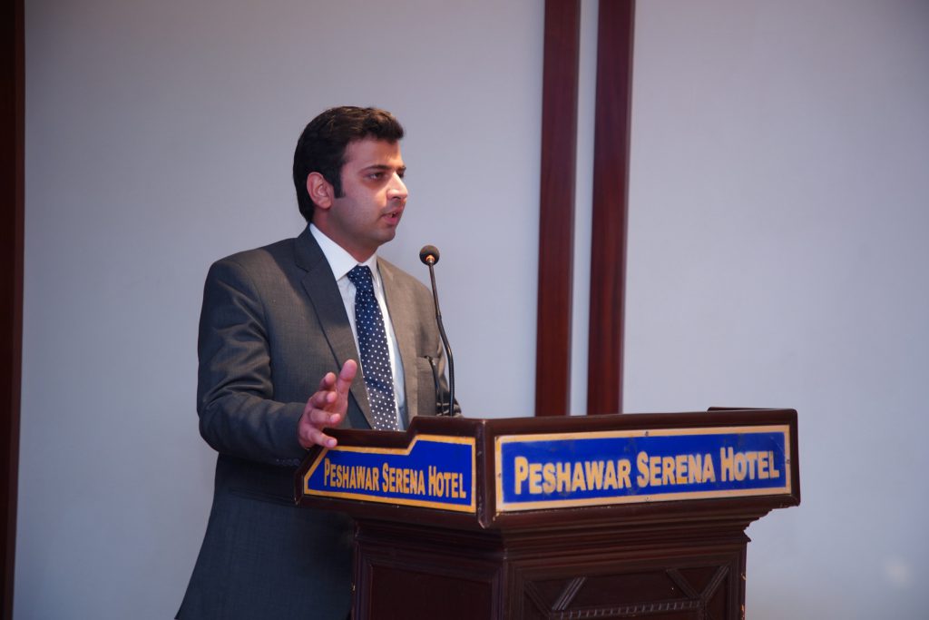 A speaker addresses the audience from a podium.